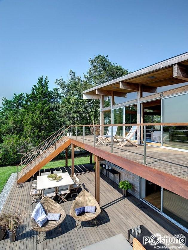 Earthy Timber Clad Interiors vs. Urban Glass Exteriors: Cottage Design by Bates Masi Architects