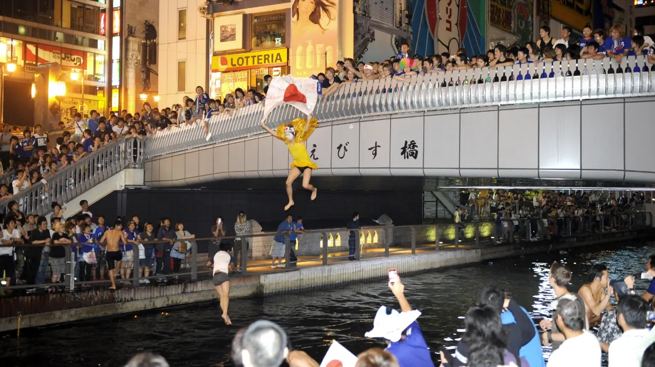 Many people celebrate by diving into the Dotonbori River.