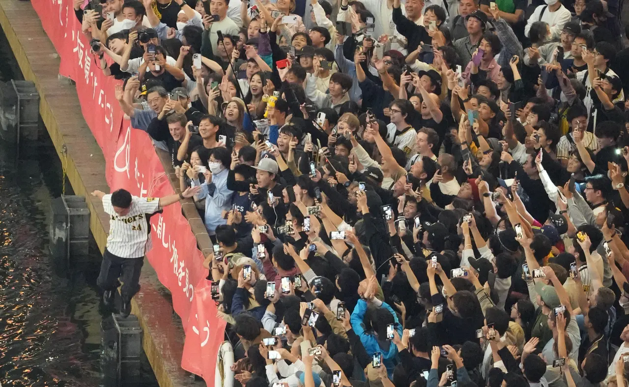 Many people celebrate by diving into the Dotonbori River.
