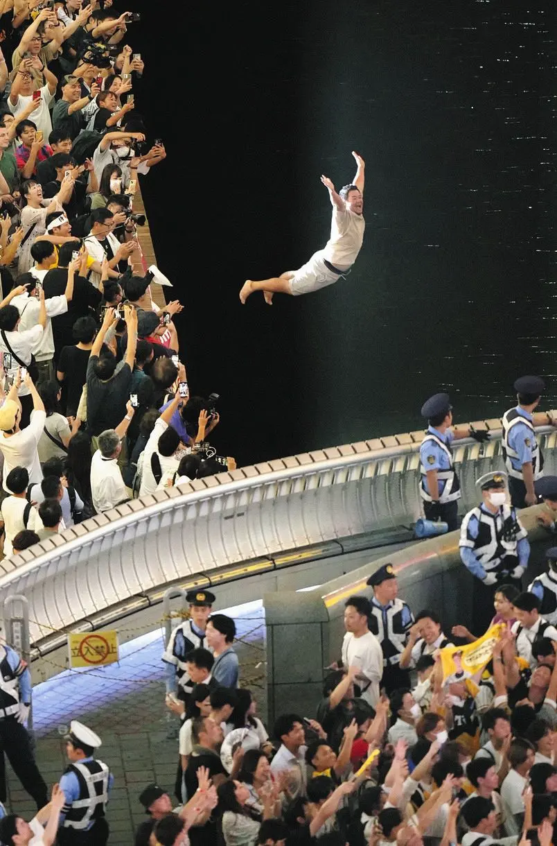 Many people celebrate by diving into the Dotonbori River.
